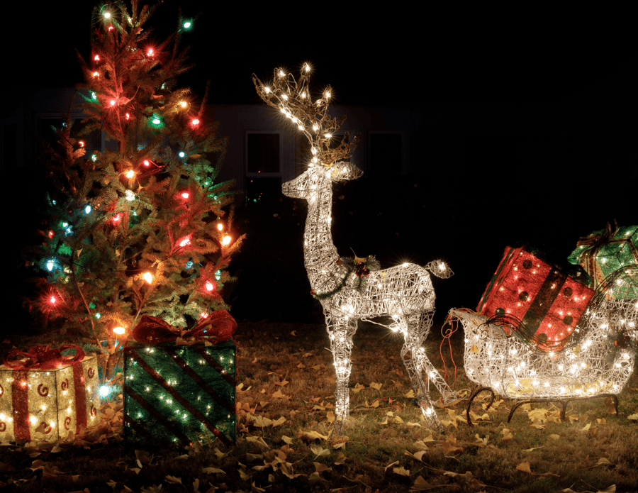 Outdoor Christmas display featuring a lighted reindeer and colorful wrapped gifts.