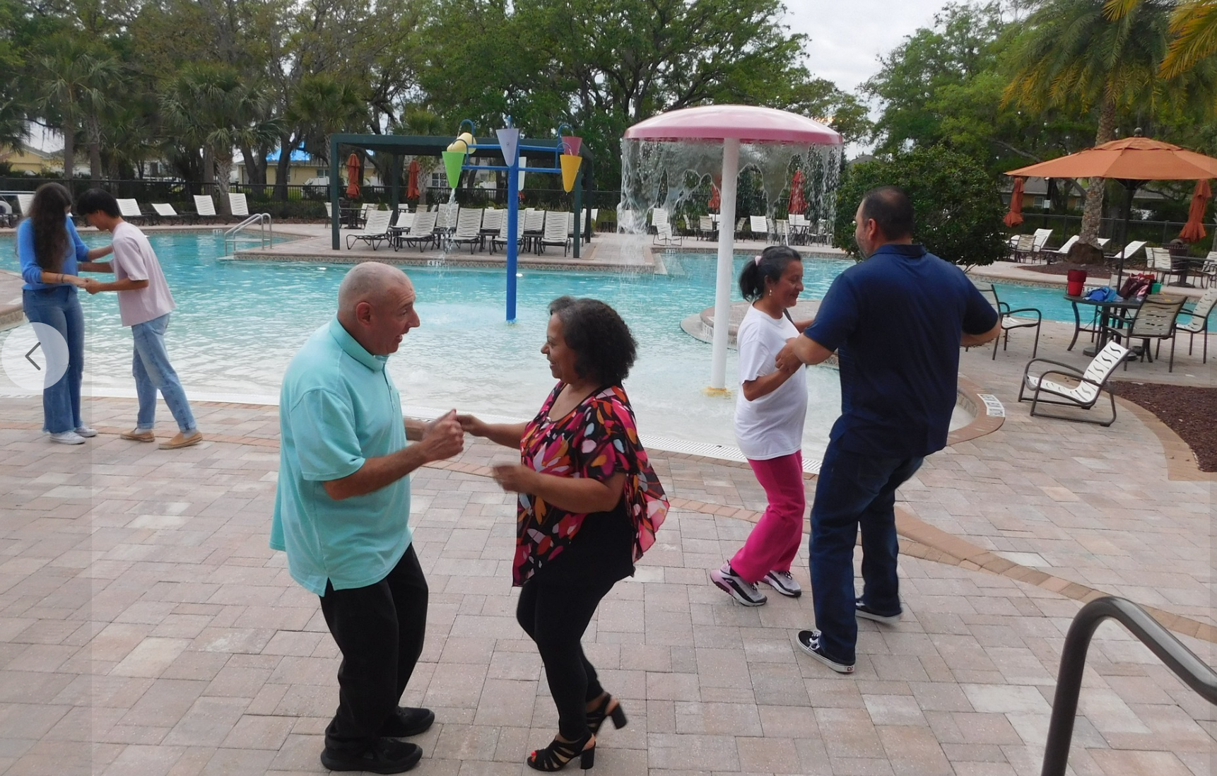 Couples enjoying dancing at a vibrant community pool party.